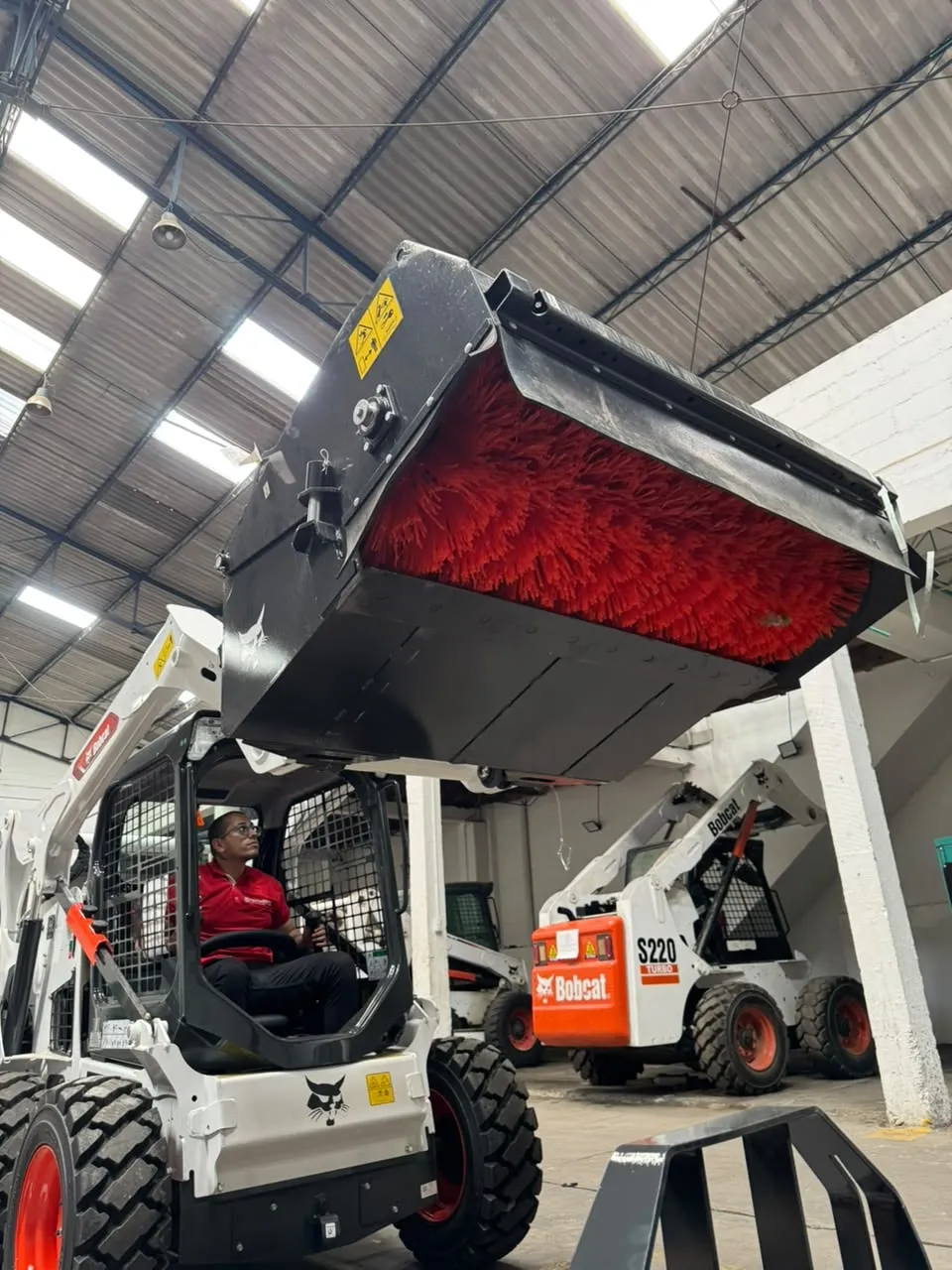 Barredora Bobcat para minicargador limpiando una vía