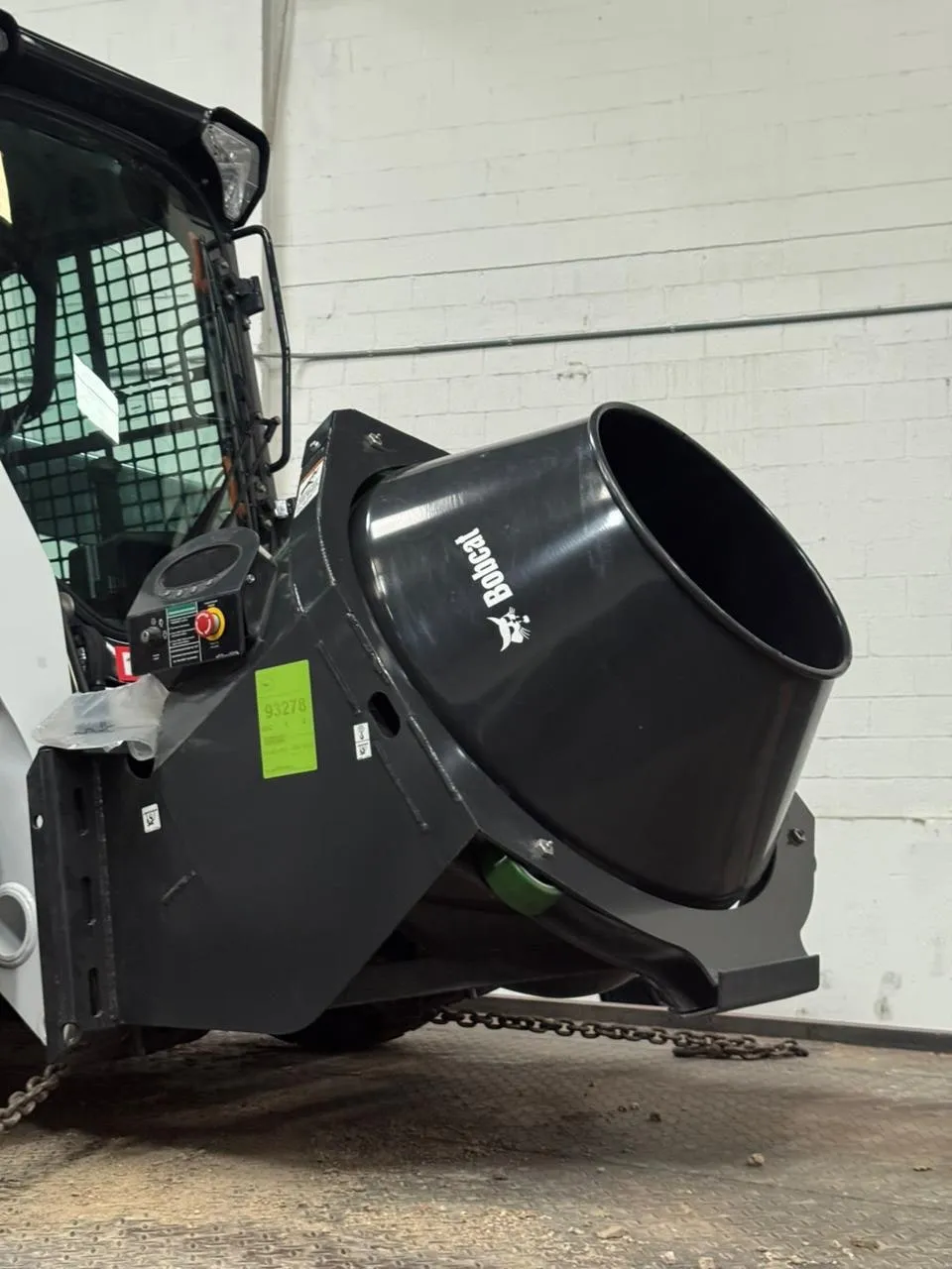 Mezcladora de concreto Bobcat para minicargador descargando mezcla