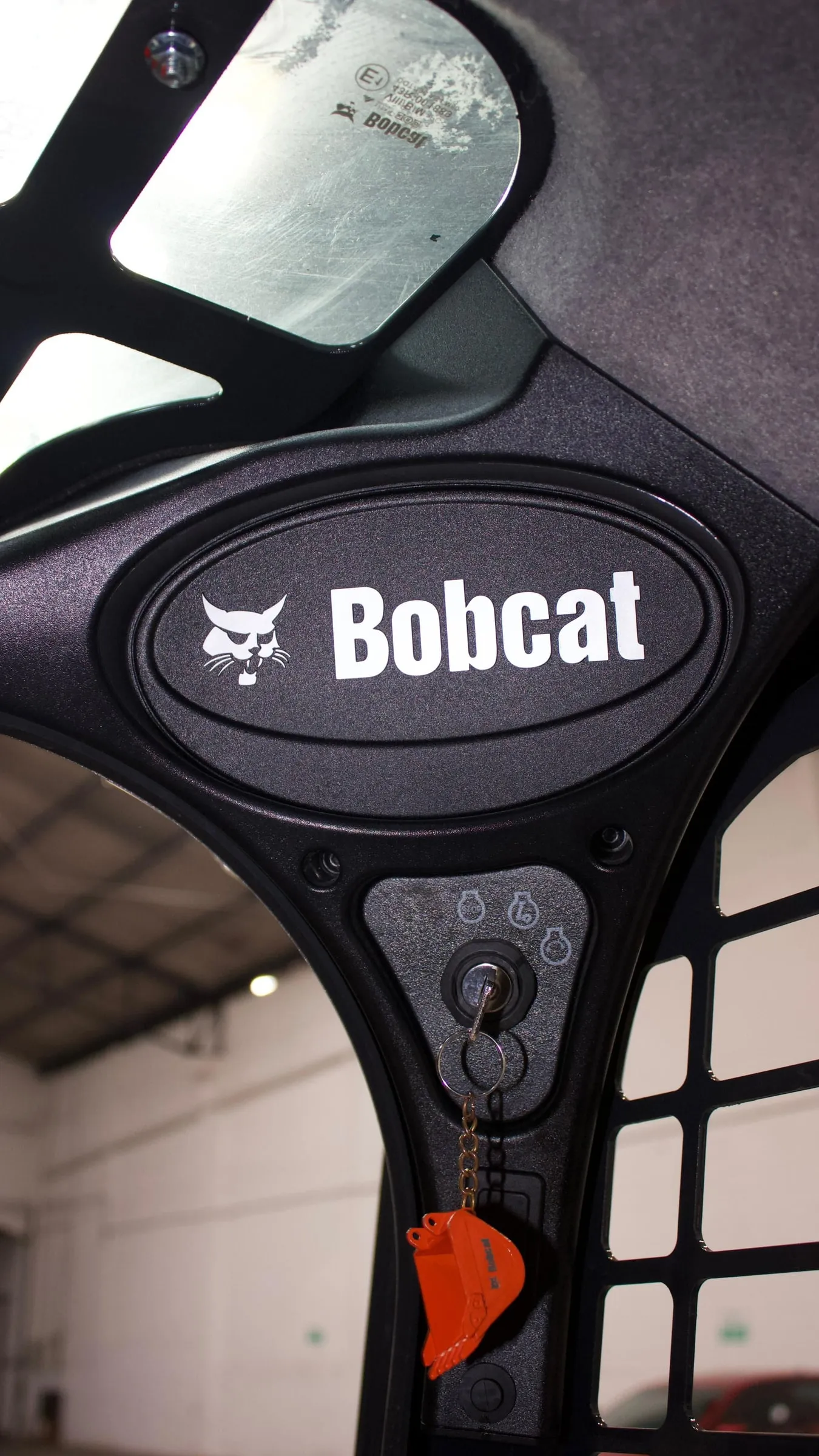 Foto vertical: logo Bobcat en la cabina de un minicargador