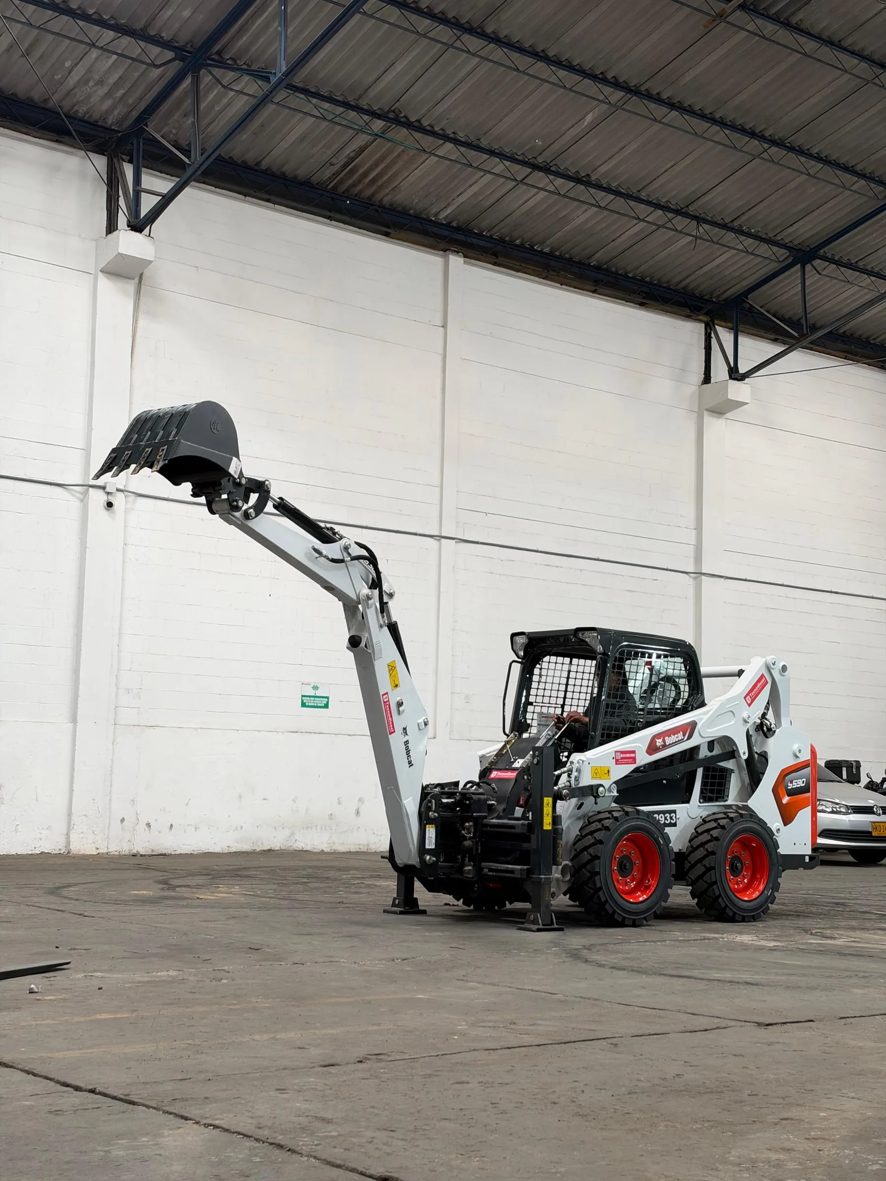 Brazo excavador Bobcat B32V montado en minicargador abriendo una zanja — vista 3